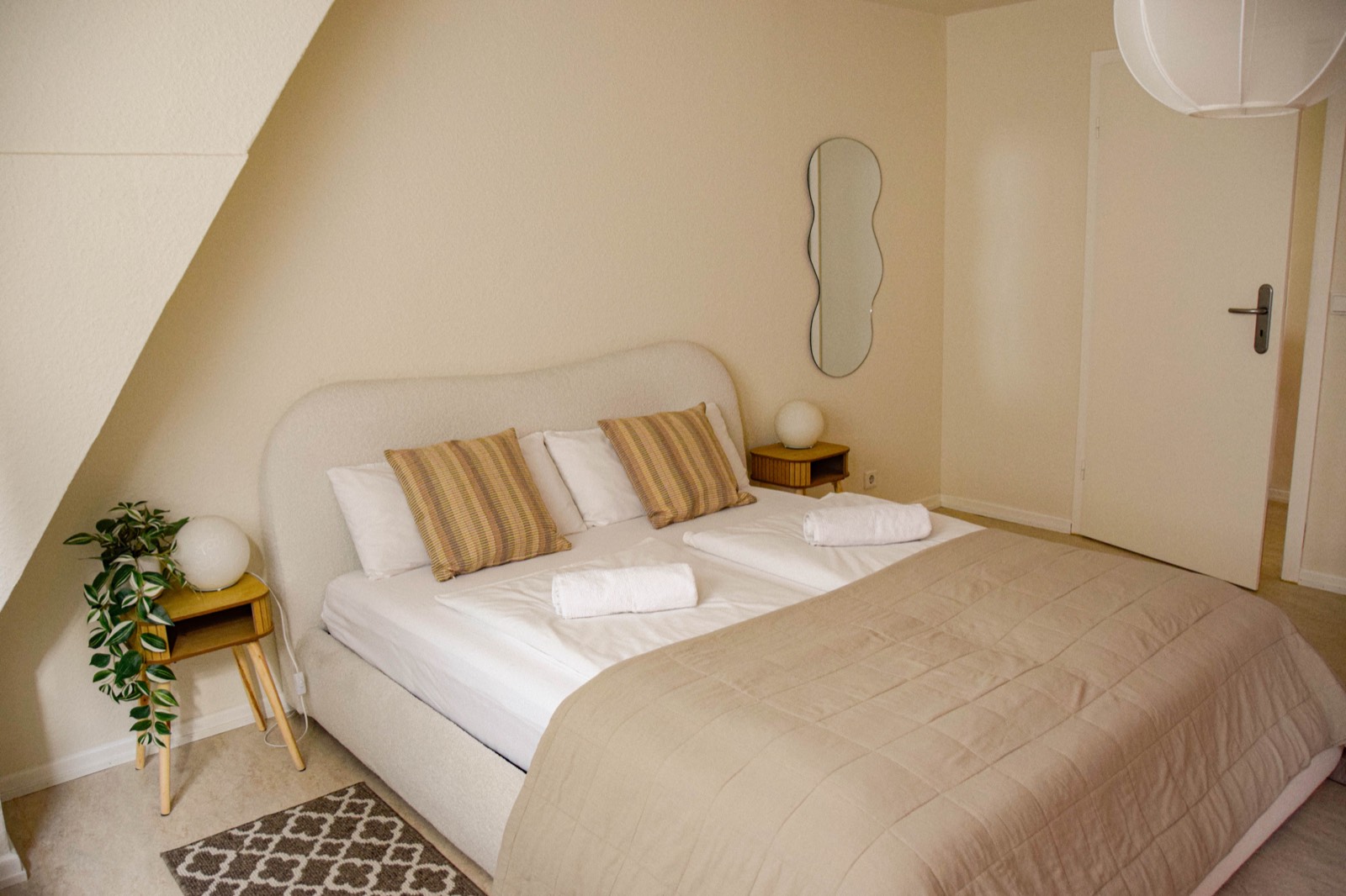 Schlafzimmer mit Doppelbett, Nachttisch und Spiegel